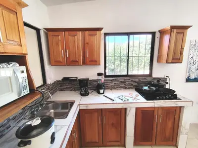 a small kitchen with a sink and a microwave at Casa Chika, Playa Grande Guanacaste, Casa Completa in Cuajiniquil
