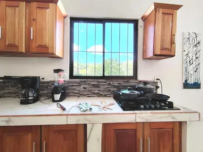a kitchen with a stove and a window at Casa Chika, Playa Grande Guanacaste, Casa Completa in Cuajiniquil
