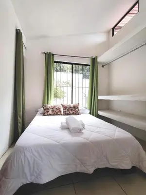 a bedroom with a large white bed with a window at Casa Chika, Playa Grande Guanacaste, Casa Completa in Cuajiniquil