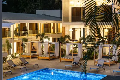 a hotel with a swimming pool in front of a building at Lia Hotel Jaco - Adults Only in Jacó