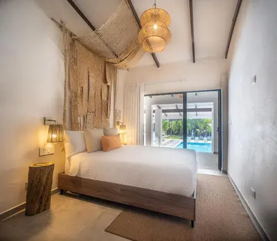 a bedroom with a bed and a view of a pool at Lia Hotel Jaco - Adults Only in Jacó