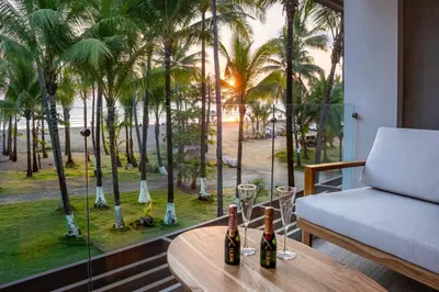 a room with a table and a window with palm trees at Lia Hotel Jaco - Adults Only in Jacó