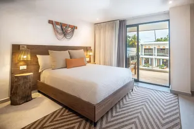 a bedroom with a large bed and a balcony at Lia Hotel Jaco - Adults Only in Jacó