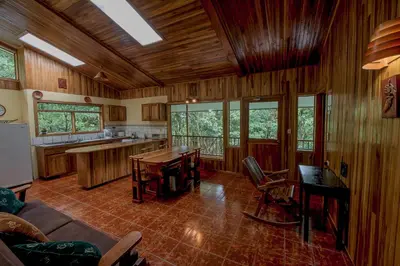 a large kitchen with wooden walls and wooden flooring at Hospedaje Mariposa in Monteverde Costa Rica