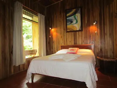 a bedroom with a bed in a room with a window at Hospedaje Mariposa in Monteverde Costa Rica