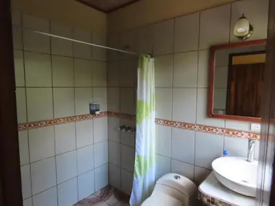 a bathroom with a shower curtain and a sink at Hospedaje Mariposa in Monteverde Costa Rica