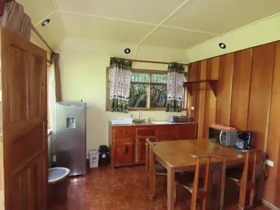 a kitchen with a table and a refrigerator at Hospedaje Mariposa in Monteverde Costa Rica