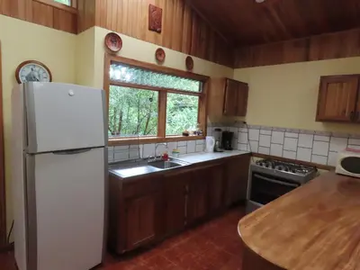 a kitchen with a white refrigerator and a window at Hospedaje Mariposa in Monteverde Costa Rica