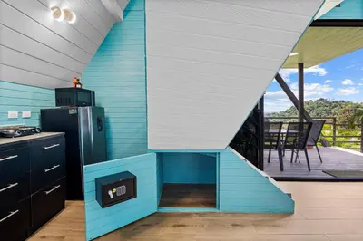 a blue and white kitchen with a staircase leading to a deck at Junglo Resort and Spa in Fortuna