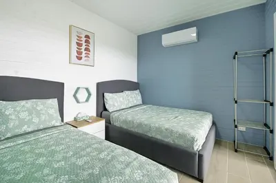 two beds in a room with blue walls at Junglo Resort and Spa in Fortuna