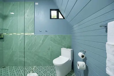 a bathroom with a toilet and a glass shower at Junglo Resort and Spa in Fortuna