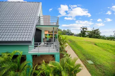 a house with a balcony and a lawn at Junglo Resort and Spa in Fortuna