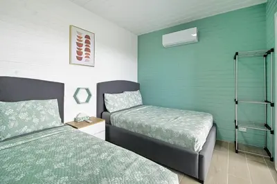 a bedroom with two beds and green walls at Junglo Resort and Spa in Fortuna