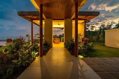 a walkway leading to a house with a pergola at Casa Bella Vina - by Pura Villas in Dominical