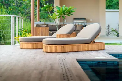 a pool with two lounge chairs next to a pool at Casa Bella Vina - by Pura Villas in Dominical