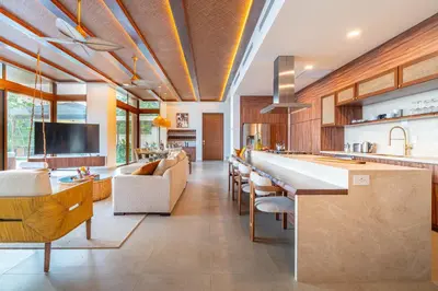 a large kitchen with a bar and some chairs at Casa Bella Vina - by Pura Villas in Dominical