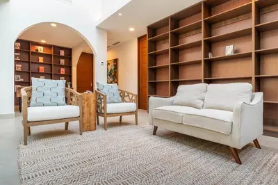 two chairs and a couch in a room with shelves at Casa Bella Vina - by Pura Villas in Dominical