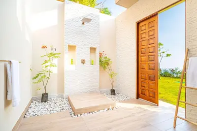 a bathroom with a wooden door and a walk in shower at Casa Bella Vina - by Pura Villas in Dominical