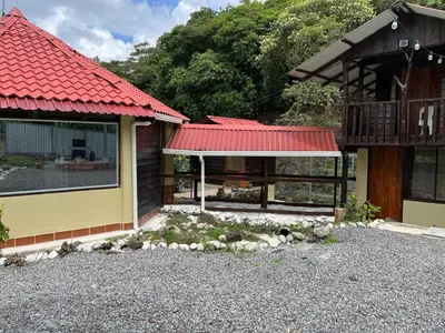 a house with a red roof and a gravel driveway at Aire Agua y Naturaleza in Guácimo