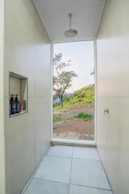 a bathroom with a large window and a walk in shower at Casa Clara Monteverde in Puntarenas