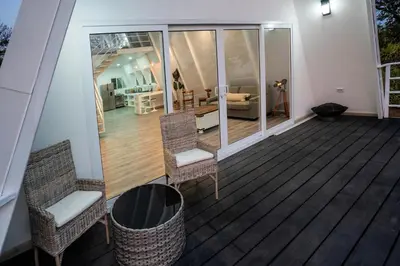 a balcony with two chairs and a living room at Casa Clara Monteverde in Puntarenas