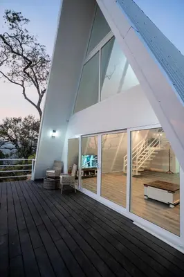 a large house with a large deck with glass windows at Casa Clara Monteverde in Puntarenas