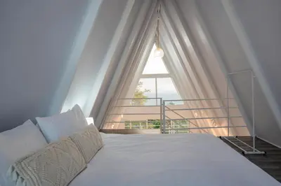 a bedroom with a bed with a large window at Casa Clara Monteverde in Puntarenas