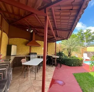a patio with a white table and a kitchen at Villas BRENES in Uvita