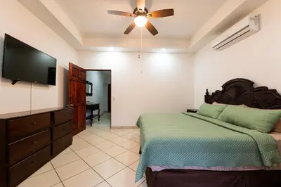 a bedroom with a bed and a flat screen tv at Villa Tropical by Vacation Pura Vida in Esterillos Este