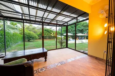 a screened in porch with a table and a view of a yard at Villa Tropical by Vacation Pura Vida in Esterillos Este