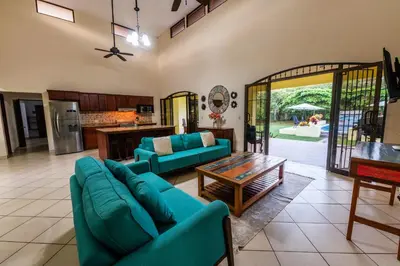 a living room with blue couches and a table at Villa Tropical by Vacation Pura Vida in Esterillos Este