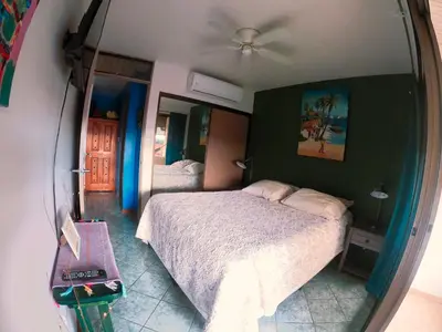 a bedroom with two beds and a ceiling fan at Samara Beach Las Palmeras Condo with Ocean view in Sámara