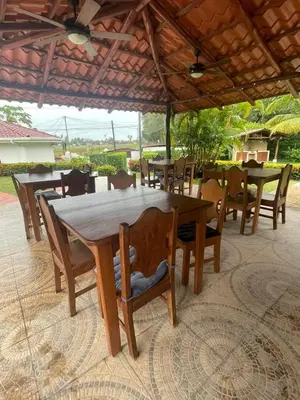 a wooden table and chairs under an umbrella at Samara Beach Las Palmeras Condo with Ocean view in Sámara