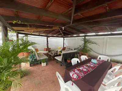 a screened in porch with a table and chairs at Hospedaje Casa Mar in Liberia