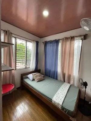 a bedroom with a bed in a room with windows at Hospedaje Casa Mar in Liberia