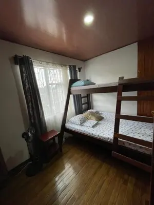 a bedroom with two bunk beds and a chair at Hospedaje Casa Mar in Liberia