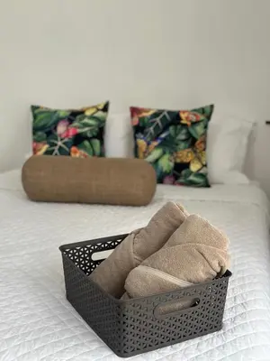 a basket on a bed with towels in it at Hotel Boutique CasAguacate close to Airport, Pedregal, Centro de Convenciones de Costa Rica in Potrerillos