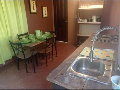 a kitchen with a table with chairs and a sink at Fruta mango # 3 in Playa Guacalillo