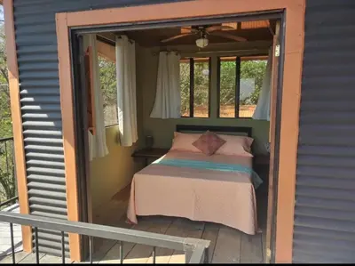 a bed on the porch of a house at Fruta mango # 3 in Playa Guacalillo