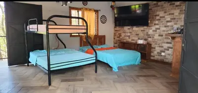 a room with two bunk beds and a flat screen tv at Fruta mango # 3 in Playa Guacalillo