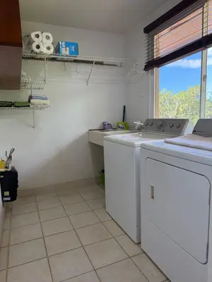 a kitchen with a washing machine and a sink at Refugio de paz in Jacó