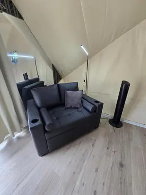 a living room with a black couch and a lamp at Pacific Glamp in Potrero