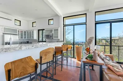 a living room with a bar and some chairs at Casa Buena Vista with Incredible Ocean Views in Playa Hermosa
