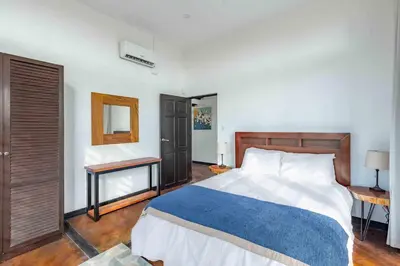 a bedroom with a large bed with a blue blanket at Casa Buena Vista with Incredible Ocean Views in Playa Hermosa