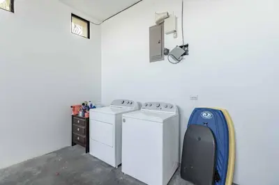 a laundry room with two washing machines and a camera at Casa Buena Vista with Incredible Ocean Views in Playa Hermosa