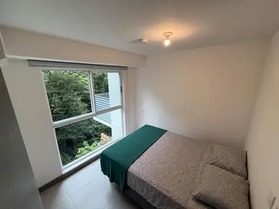 a bedroom with a bed and a large window at Punta Esmeralda Paradise in Tarcoles
