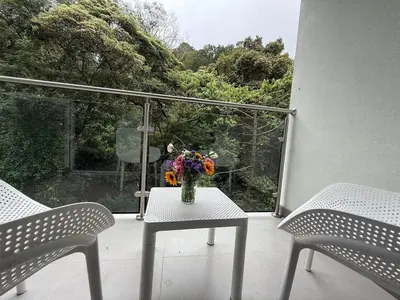 a vase of flowers sitting on a table on a balcony at Punta Esmeralda Paradise in Tarcoles