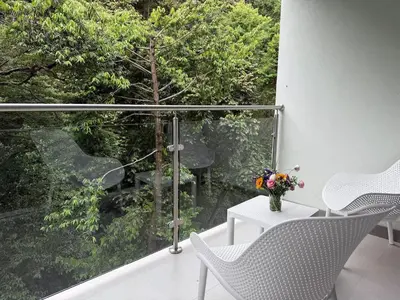 a balcony with two chairs and a vase of flowers on a table at Punta Esmeralda Paradise in Tarcoles
