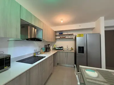 a kitchen with a refrigerator and a table in it at Punta Esmeralda Paradise in Tarcoles