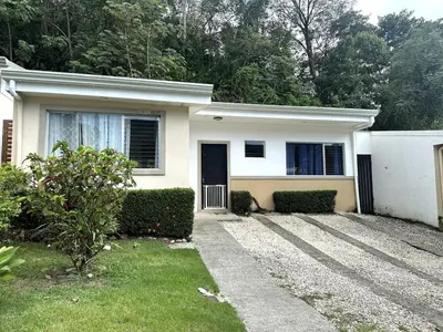 a white house with a driveway in front of it at Herradura casa vacacional in Herradura